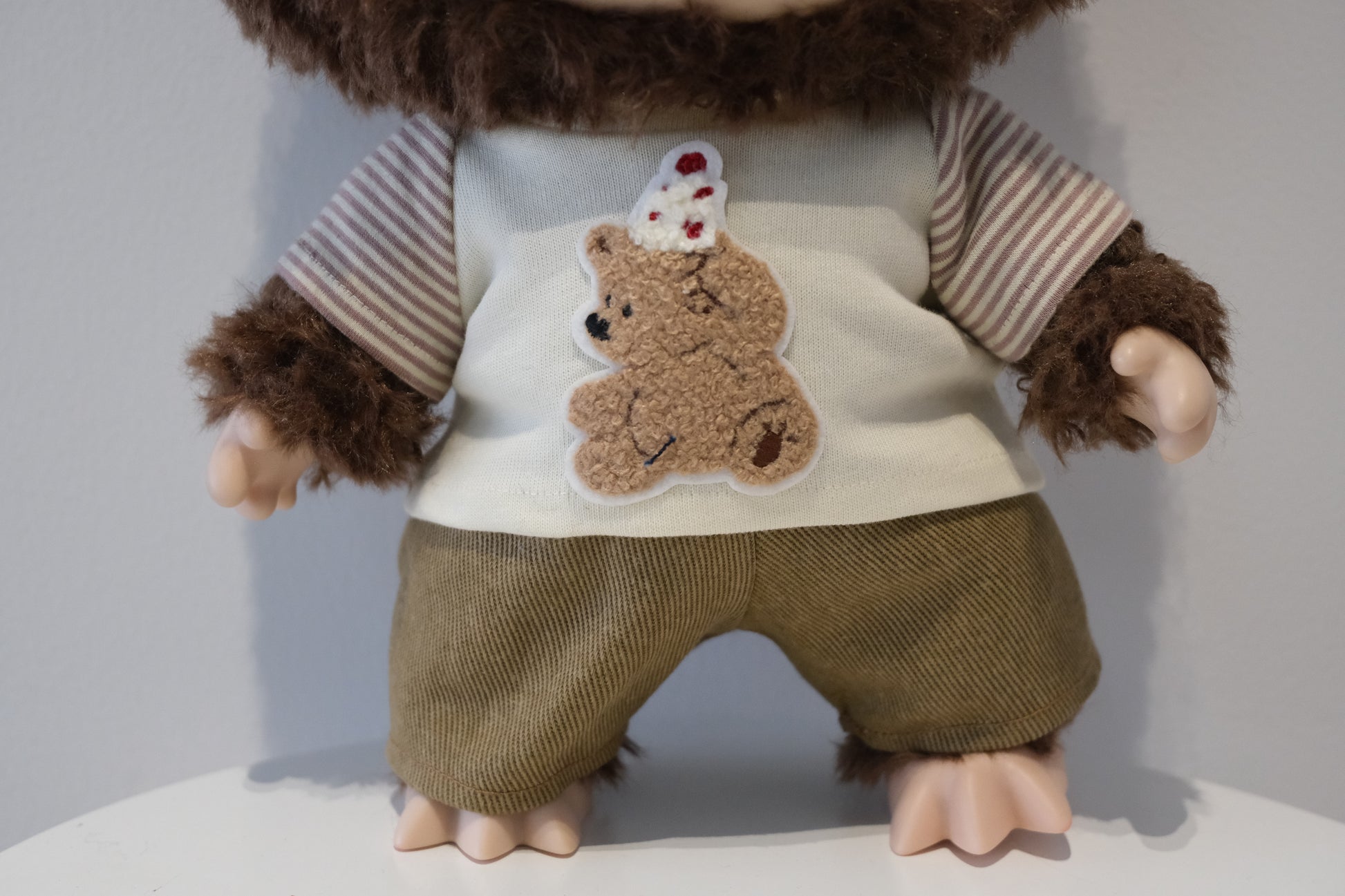 close up A cute Labubu figure dressed in a 2-piece child-style outfit from the Let's Checkmate series, featuring colorful paneled joggers and a playful graphic t-shirt.