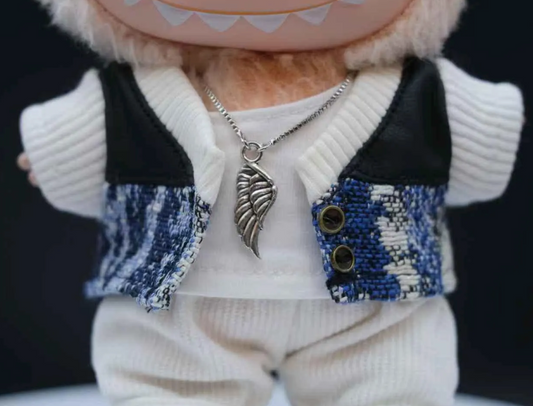 details of LABUBU plush doll wearing a textured black jacket and black and white plaid pants