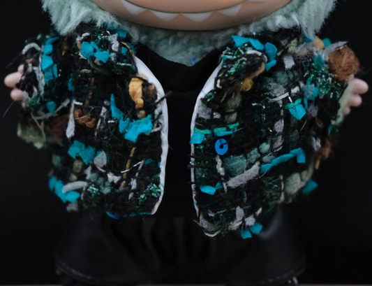 a close- up of LABUBU plush doll wearing a handmade black tweed jacket with blue and green threads
