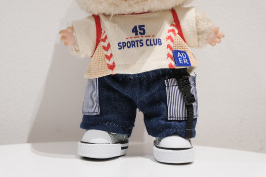 Close-up of The labubu figure's distressed denim cap and graphic t-shirt