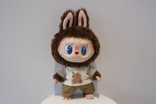 A cute Labubu figure dressed in a 2-piece child-style outfit from the Let's Checkmate series, featuring colorful paneled joggers and a playful graphic t-shirt