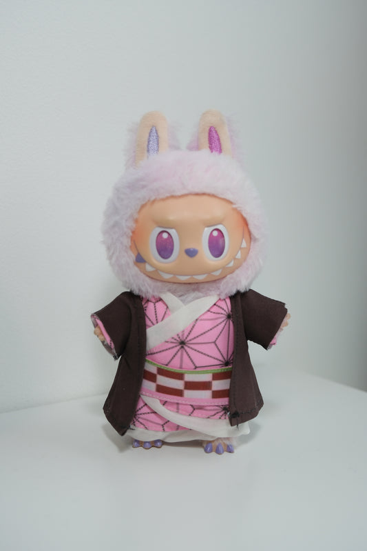 Labubu figures wearing three different Demon Slayer inspired cosplay outfits: Nezuko