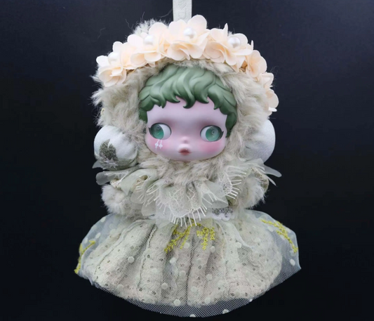 A Skullpanda figure wearing a custom-made, mint-colored feather dress and a fluffy cap with lace trim