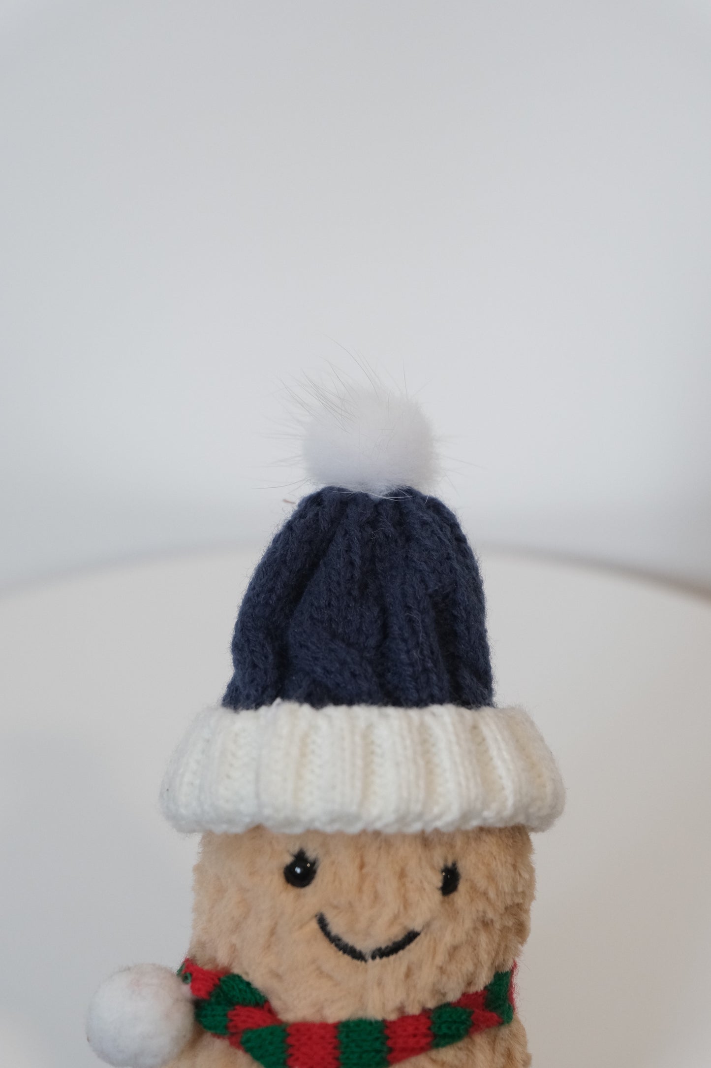 Close-up of the chunky knit hat and scarf texture on the Jellycat Amuseables Peanut plush.