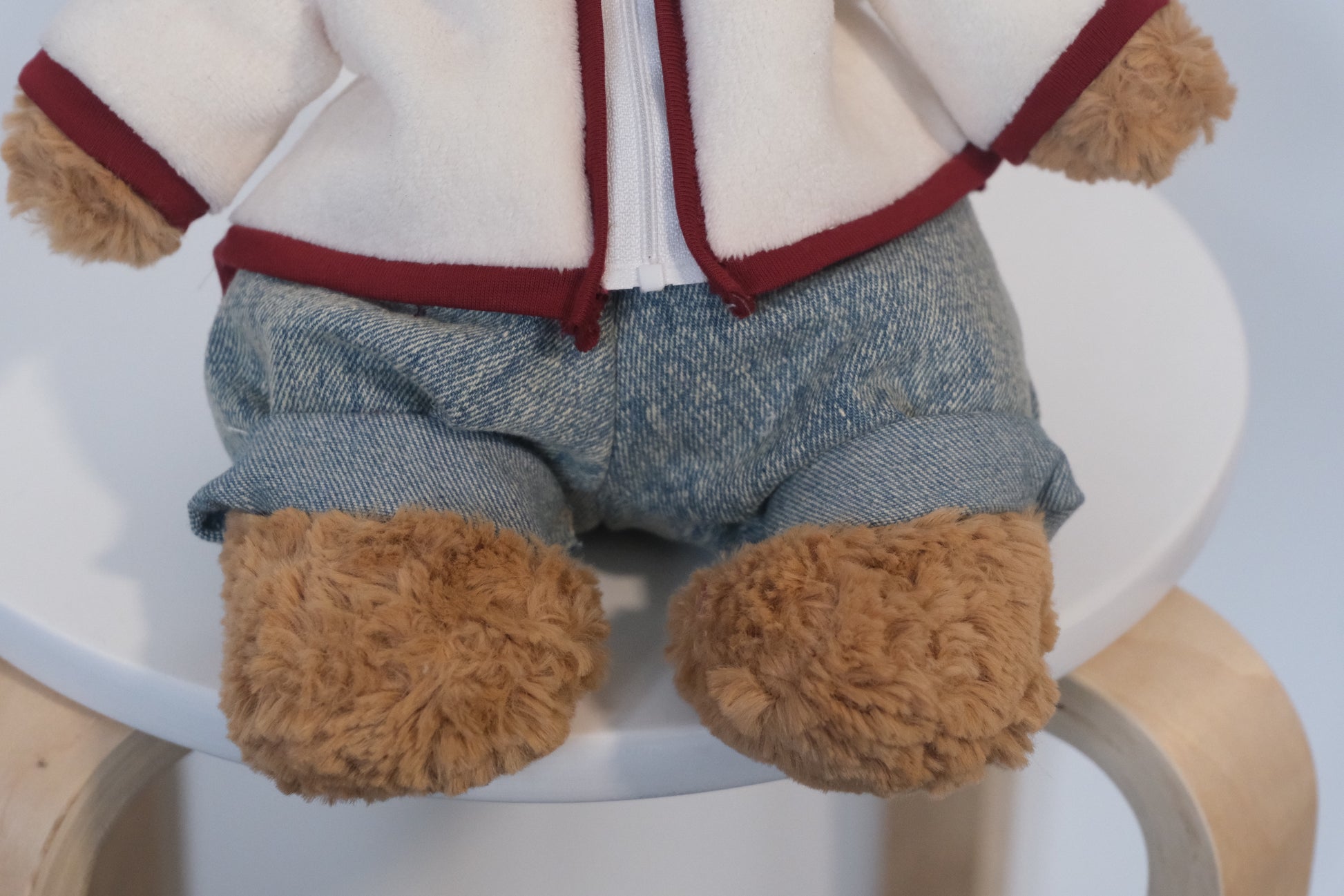 Jellycat Bartholomew Bear plush wearing a 2-piece winter outfit with a cream fleece coat and blue jeans.