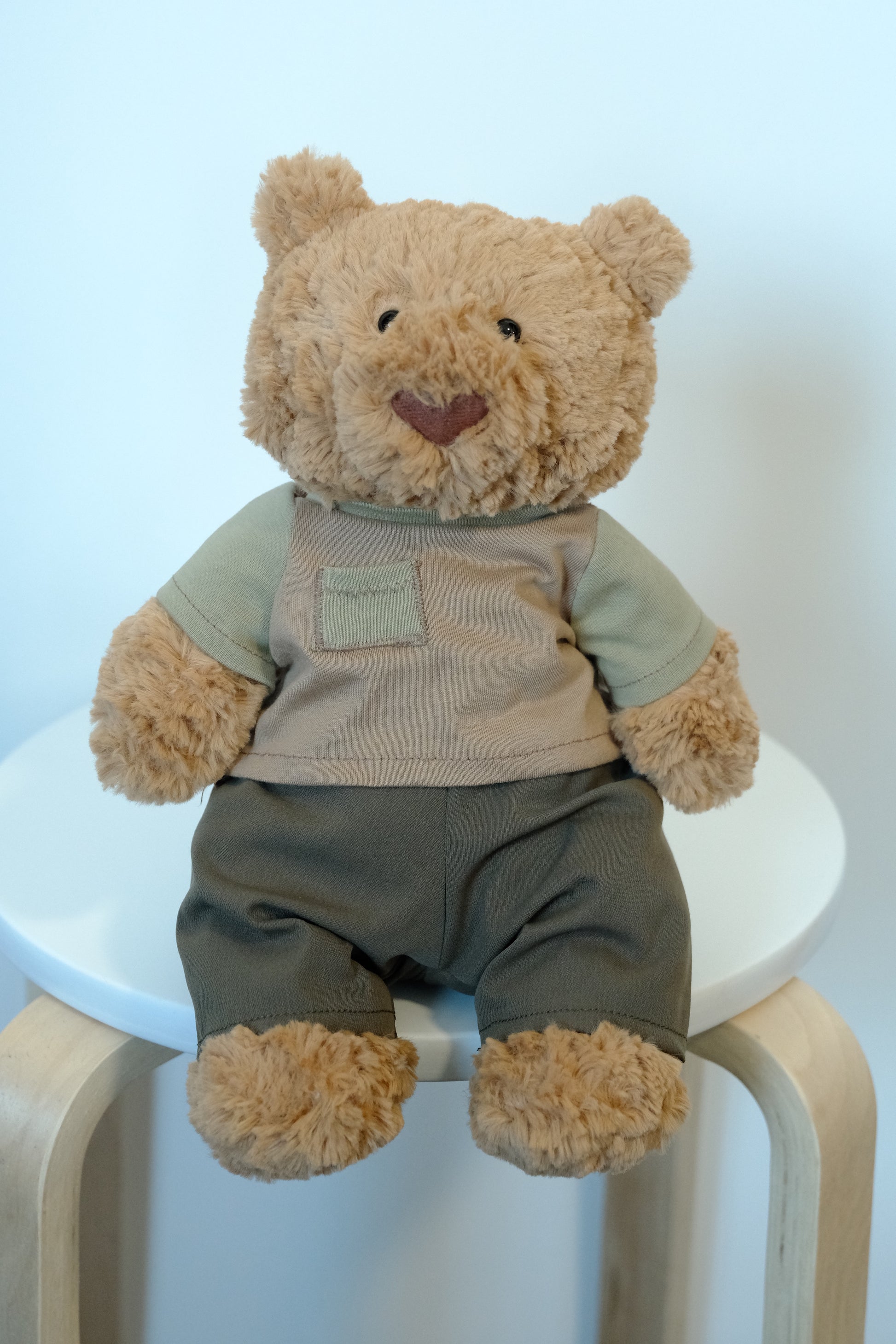 Jellycat Bartholomew Bear plush wearing a 2-piece casual outfit with a gray T-shirt and navy blue pants.