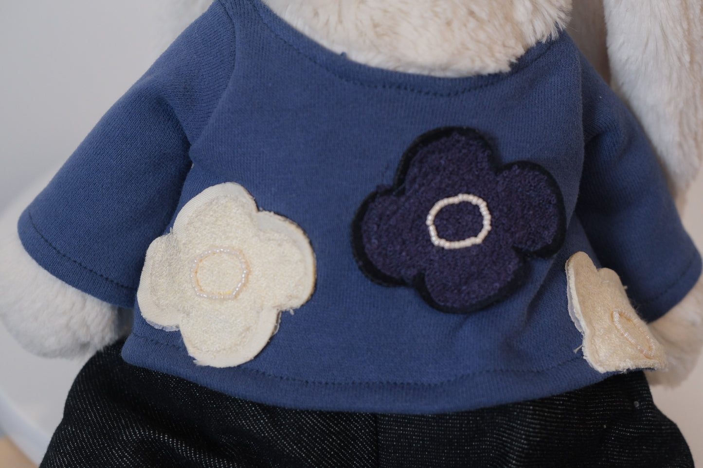 Close-up of the miniature T-shirt and pants set, showing the clean, simple fit on the Jellycat Bunny doll.