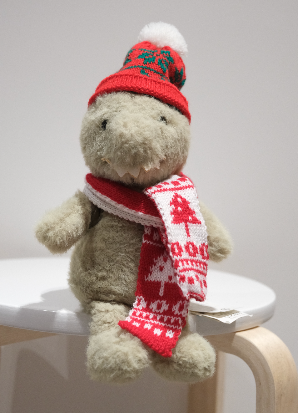 Jellycat Backpack Dinosaur wearing a 2-piece festive Christmas outfit including a Santa hat and red scarf.