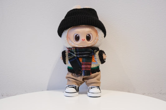 labubu wearing a black beanie, colorful scarf, and beige pants
