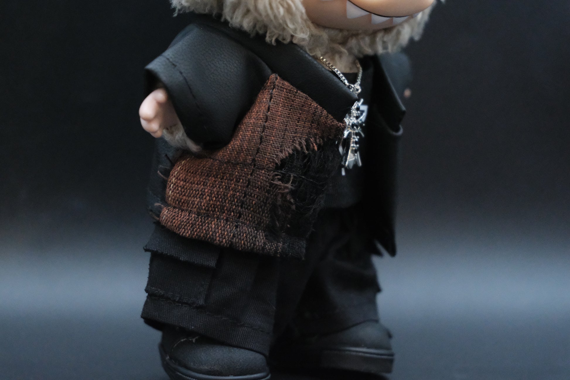 Side view of a Labubu figure wearing the full black and T-shirt outfit
