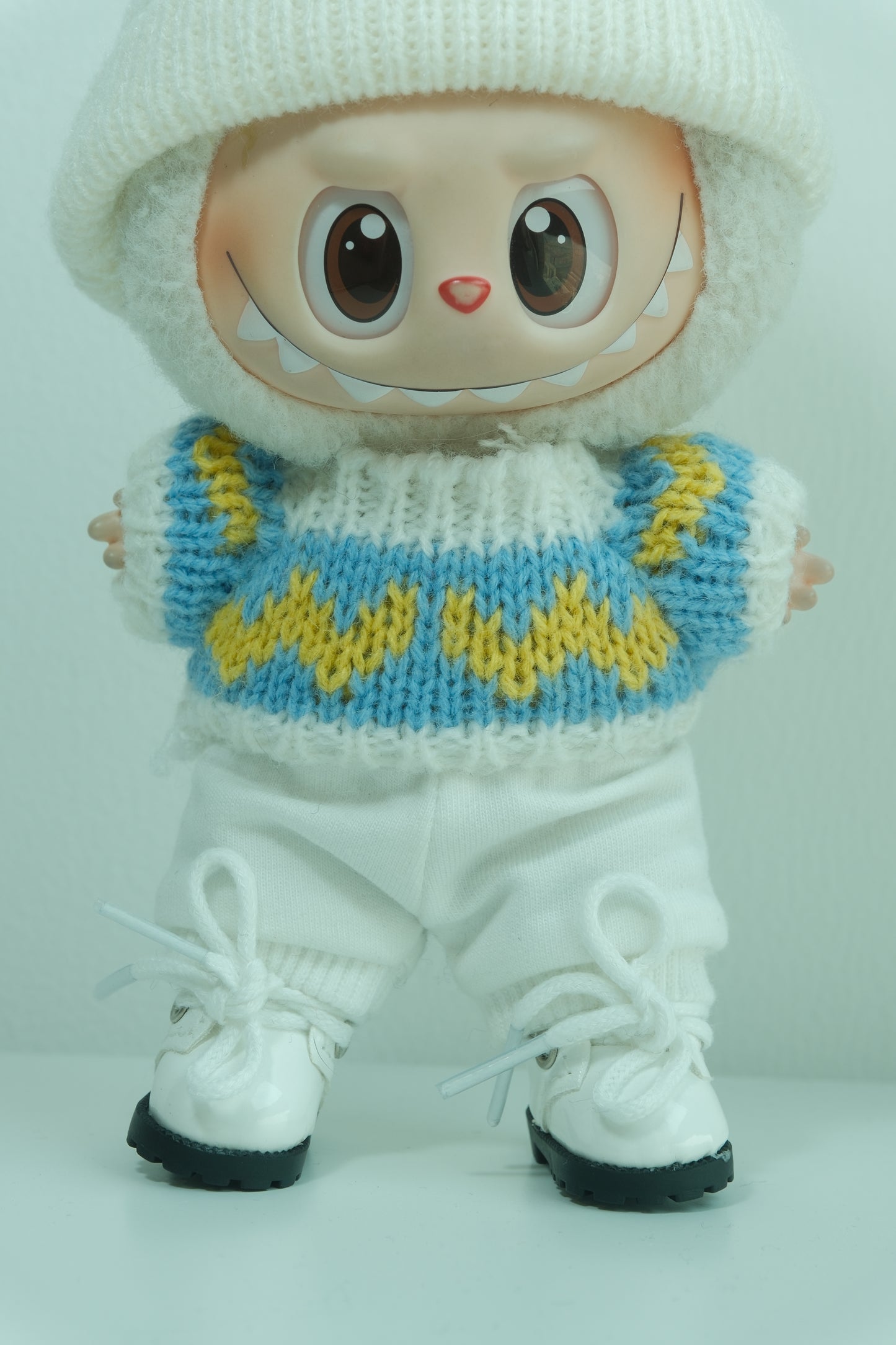 details of labubu with white shoes and a knitted blue and yellow boot cover 