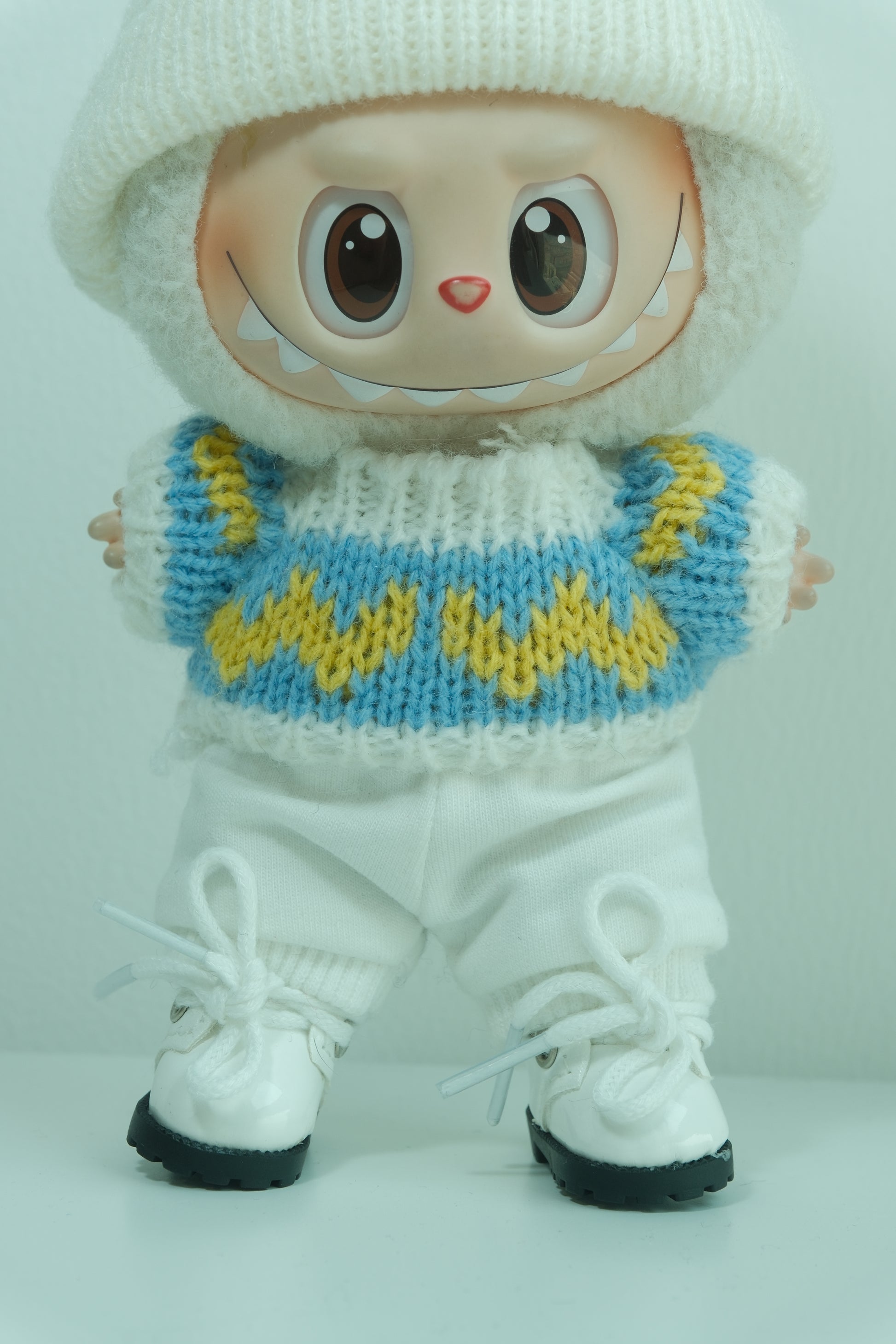 details of labubu with white shoes and a knitted blue and yellow boot cover 