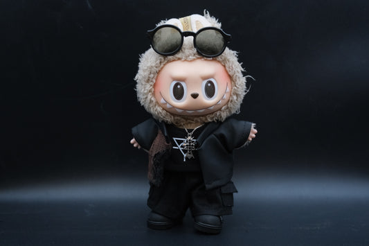 A Labubu figure wearing a 5-piece high-fashion outfit, including a black embossed jacket, black t-shirt, necklace, sunglasses and checkered pants