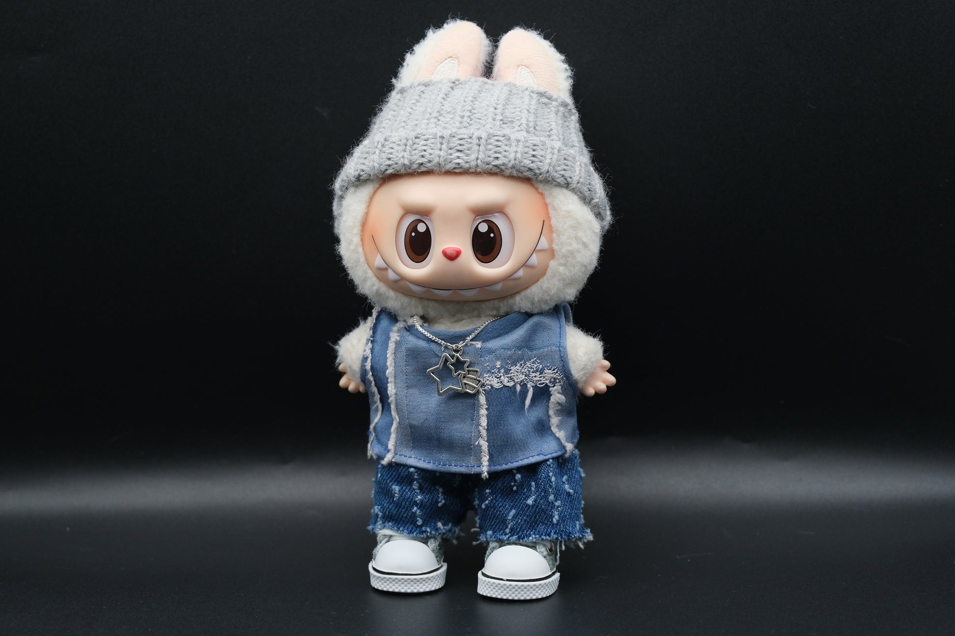  A Labubu figure from the front, slightly turned to the side, showcasing the distressed denim vest and shorts, along with the gray beanie.