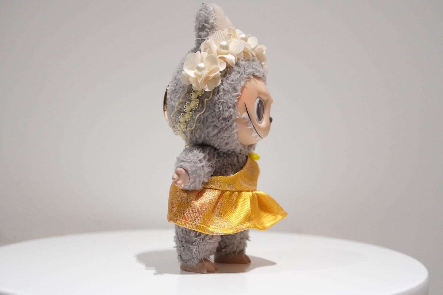 Side view of the Labubu figure in the Judy yellow evening gown, showing the draped fabric and elegant design.