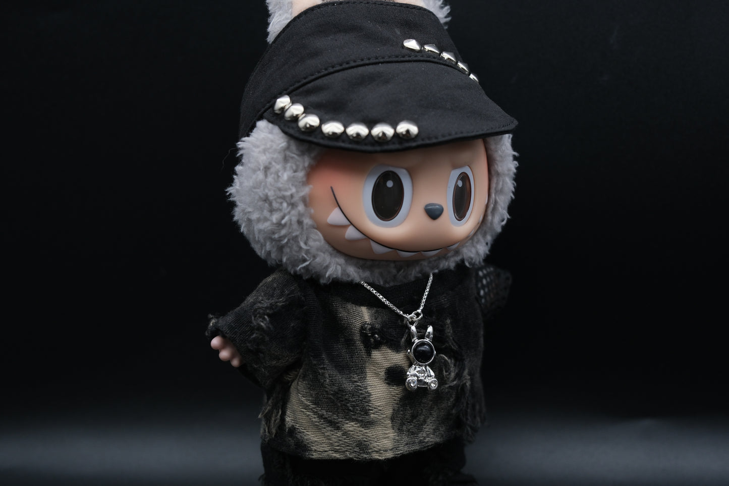  Labubu designer toy figure showcasing a modern streetwear look, featuring a punk hat , a black mixed dyeing distressed T-shirt and sliver necklace