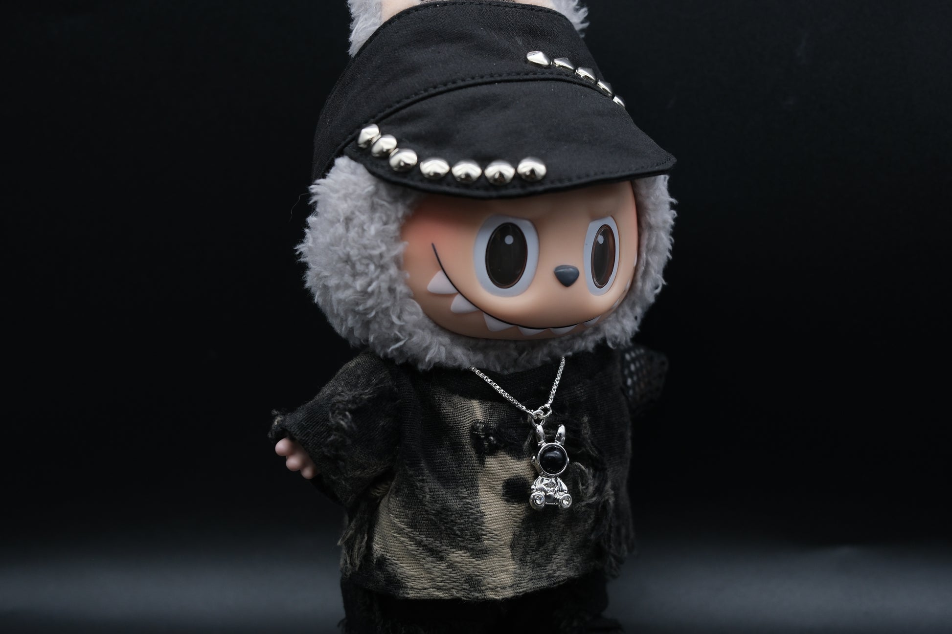  Labubu designer toy figure showcasing a modern streetwear look, featuring a punk hat , a black mixed dyeing distressed T-shirt and sliver necklace