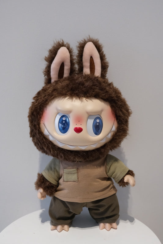 front view of Labubu figure wearing a 2-piece reconstructed utility outfit from the Let's Checkmate series, featuring multi-shaded grey paneled pants and a graphic streetwear T-shirt.