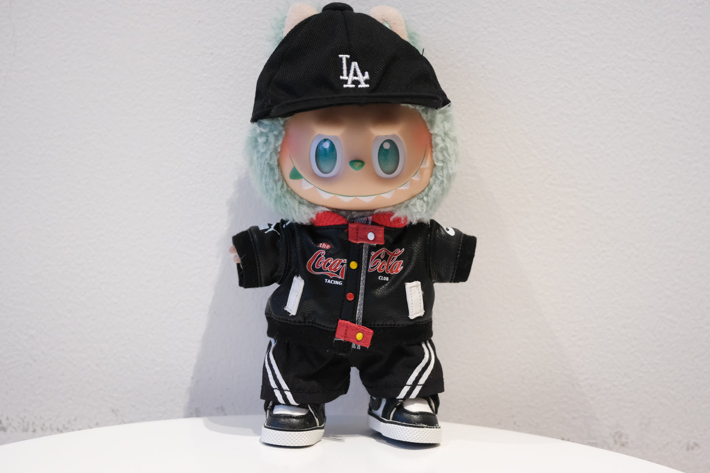 Labubu figure wearing a 5-piece Motorcore streetwear outfit with a black faux leather racing jacket and baseball cap