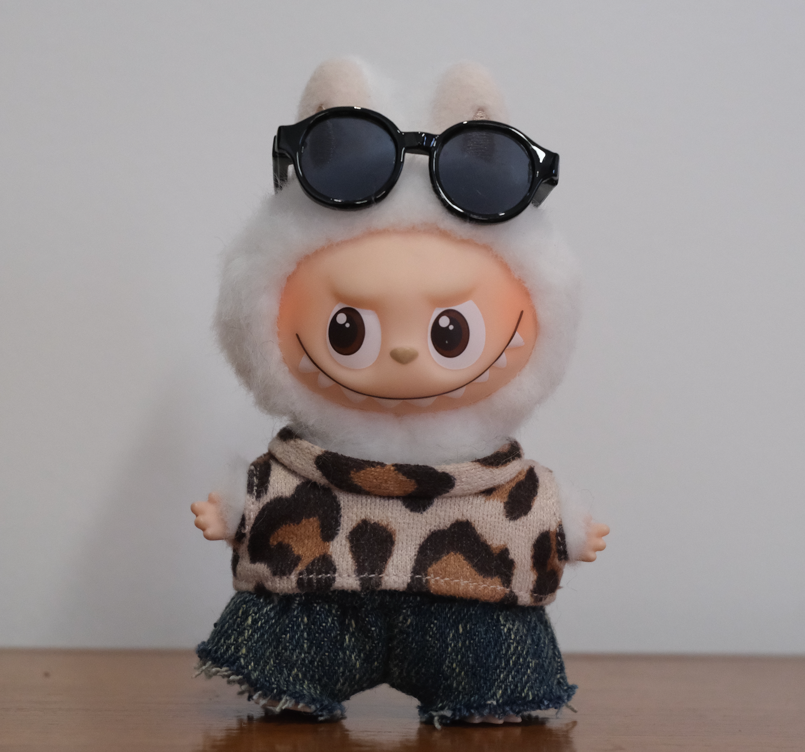 Labubu pin for love figure wearing a 3-piece fuzzy leopard print outfit with distressed denim shorts.