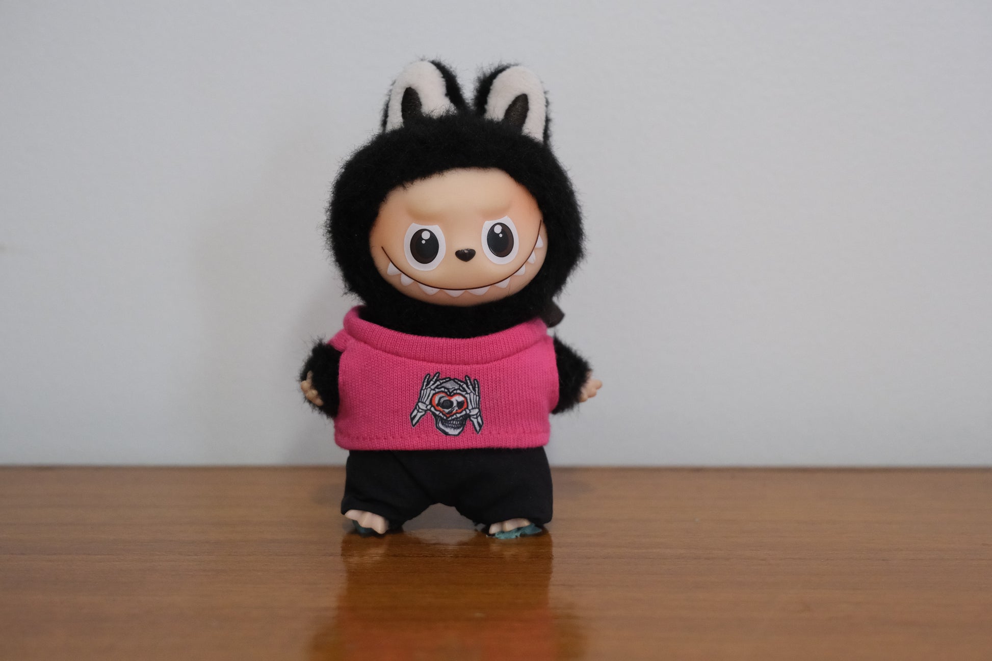 Labubu pin for love figure wearing a hot pink sweater with a skull and heart graphic