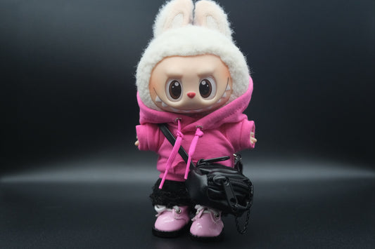 A Labubu figure wearing a pink hoodie, black pants,  crossbody bag and pink sneakers.