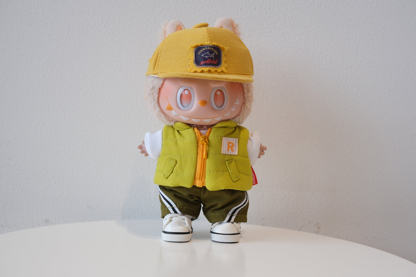 labubu wearing a yellow cap and green vest 