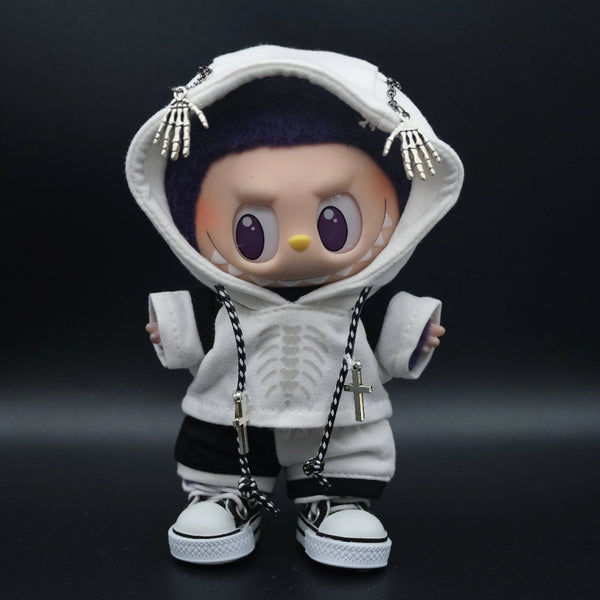  Front view of a Labubu art toy wearing a white hoodie with a skeleton ribcage graphic and a skeleton hand chain on the hood. The toy also wears black and white shorts and white high-top sneakers. Two silver cross necklaces hang from a black and white braided cord.