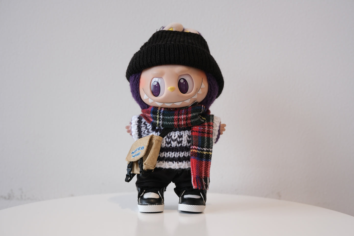 Labubu figure wearing a 6-piece winter streetwear outfit, including a striped knit sweater and black beanie