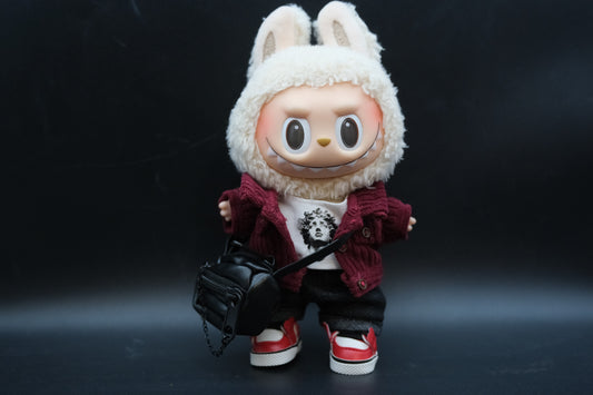 A Labubu figure wearing a 5-piece tech-wear outfit with a studded nylon jacket , jeans, bag sneakers and white t-shirt