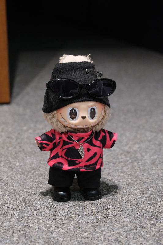 LABUBU plush doll wearing a black beanie with a safety pin, sunglasses, and a pink and black graphic t-shirt