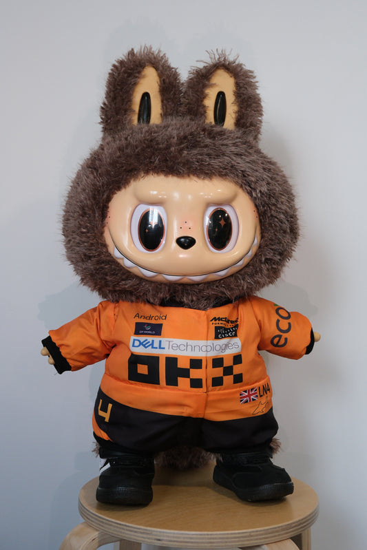 58cm Mega Zimomo wearing a McLaren F1 racing jumpsuit in orange and black