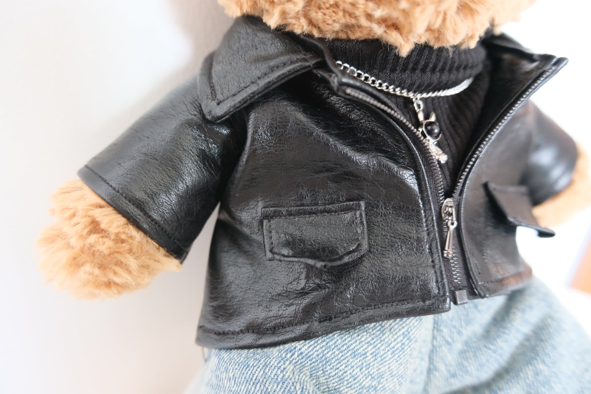 Close-up detail of the faux leather texture and miniature collar on a punk-style jacket for a Jellycat Bear.