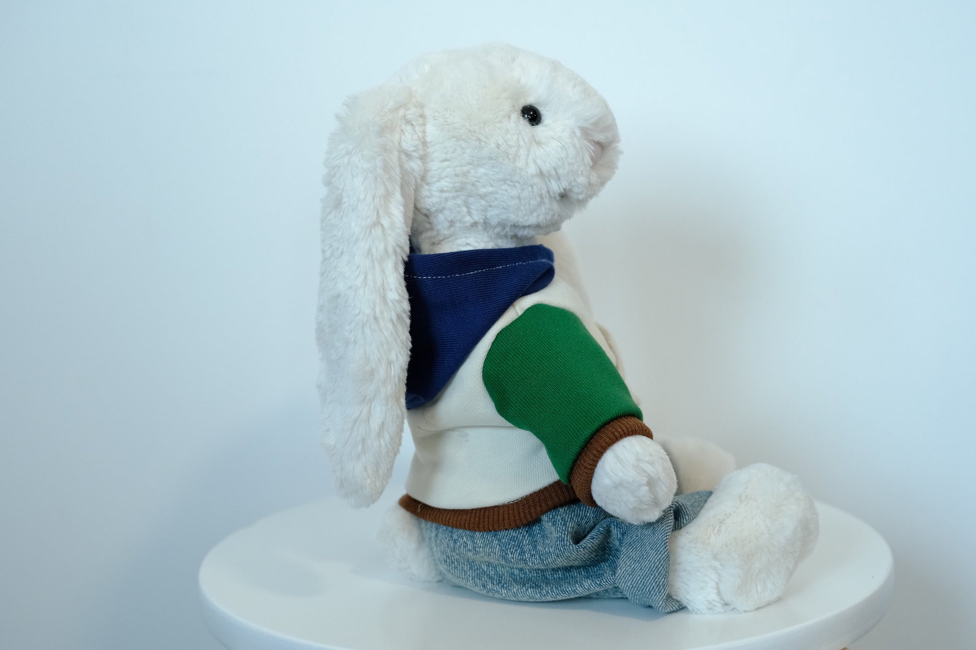 Jellycat Bashful Bunny plush wearing a 2-piece urban outfit with a gray hoodie and blue denim jeans.