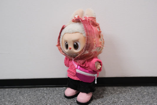 A Labubu figure in a 4-piece pink wasteland outfit, featuring a uniquely textured pink hoodie, black pants, pink shoes, and a small pink crossbody bag.