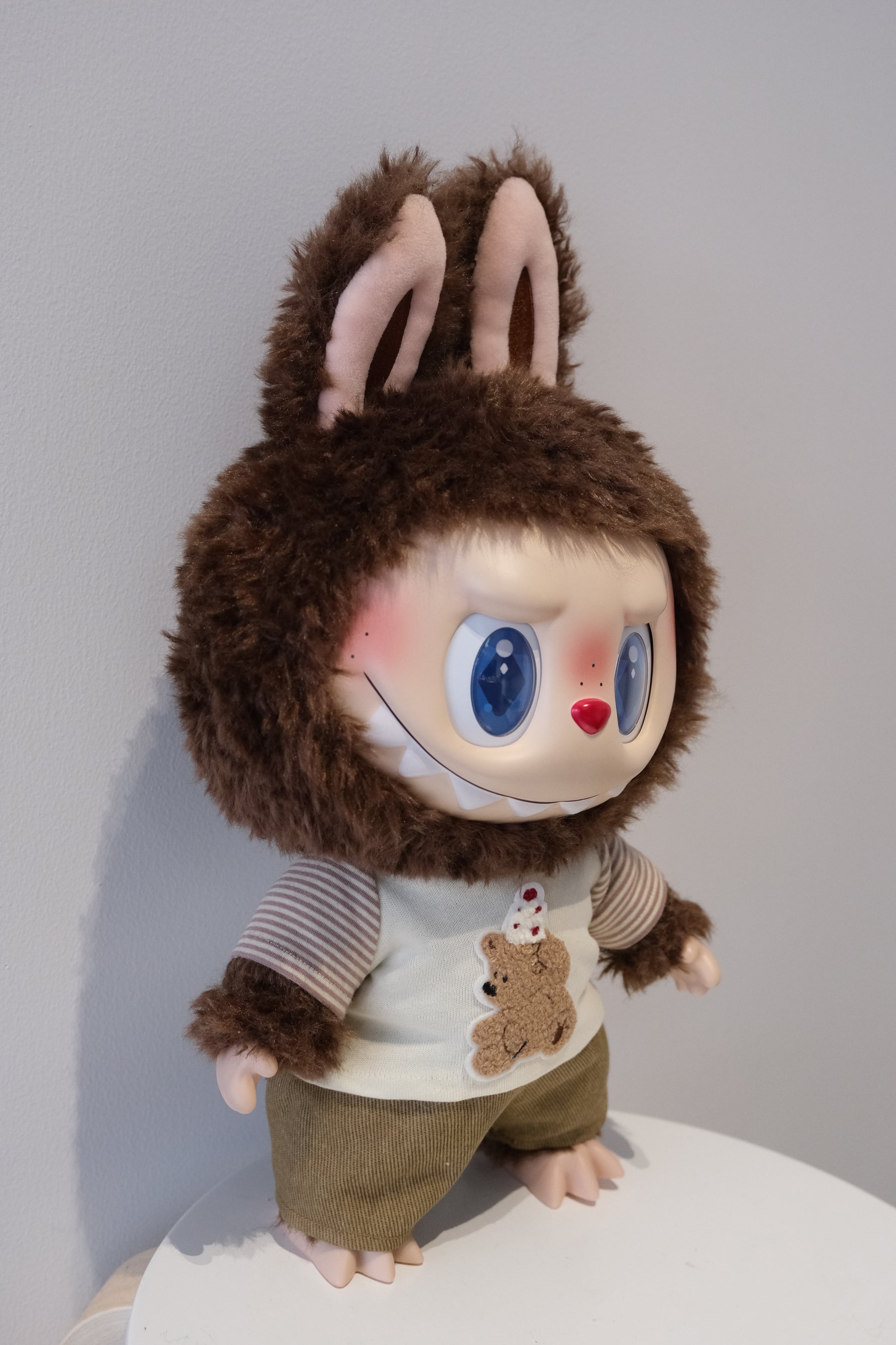 A cute Labubu figure dressed in a 2-piece child-style outfit from the Let's Checkmate series, featuring colorful paneled joggers and a playful graphic t-shirt