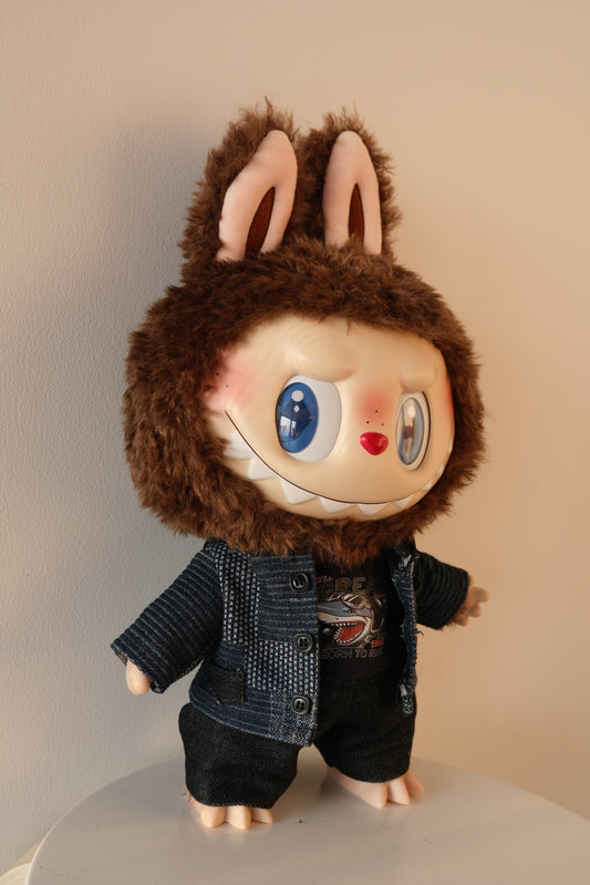 view of Labubu wearing a 3-piece patchwork denim outfit from THE MONSTERS Let's Checkmate series, featuring a multi-tonal jacket, black T-shirt, and patchwork jeans.