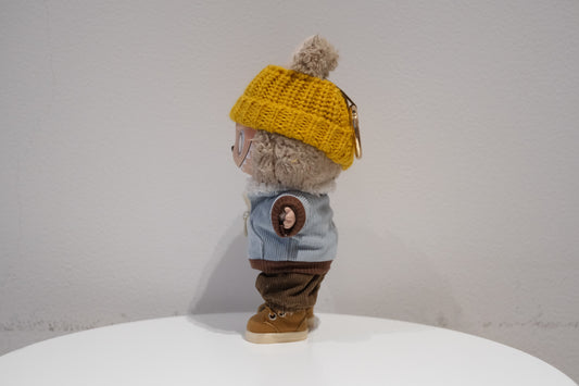 side view of Labubu figure wearing a 4-piece urban streetwear outfit with a black corduroy jacket, beanie, pants, and sneakers.