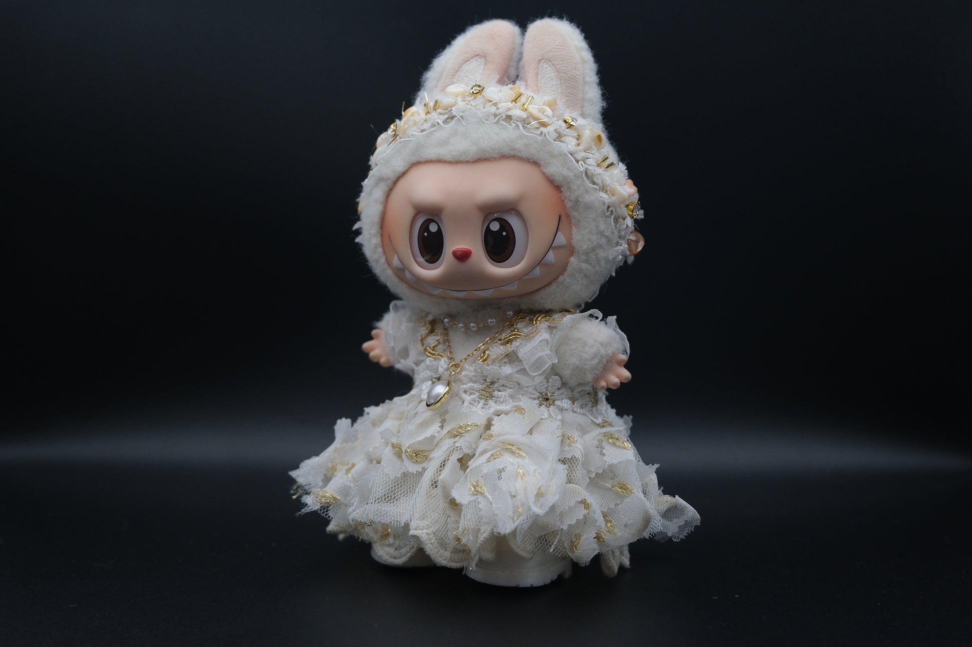 side view of Labubu figure wearing a 3-piece white frill dress, necklace, and shoes, representing the Coquette or Angel Core aesthetic