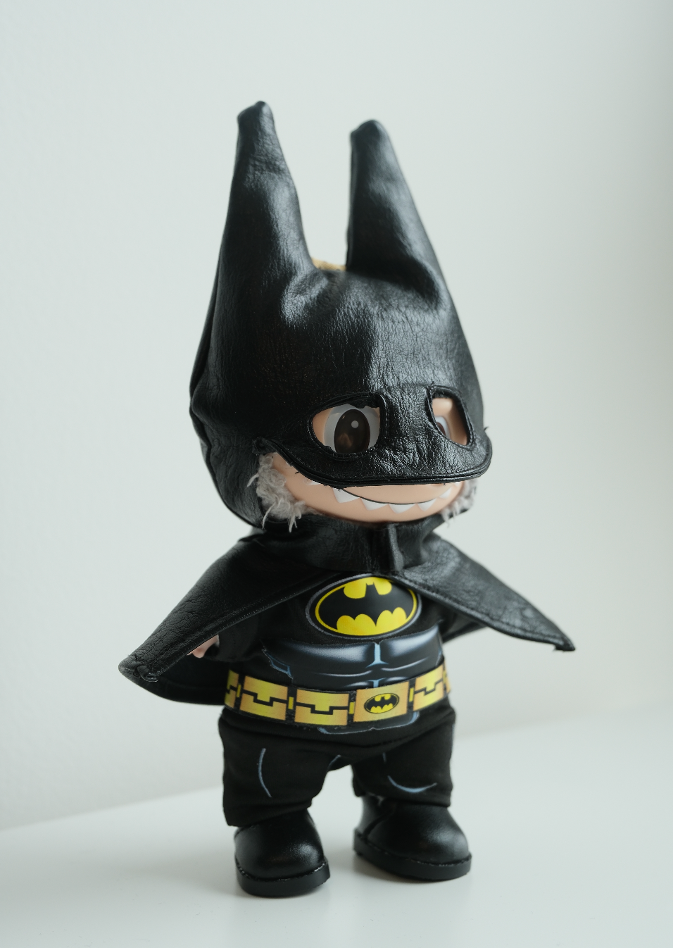 side view of labubu Batman toy figure with cape and mask 