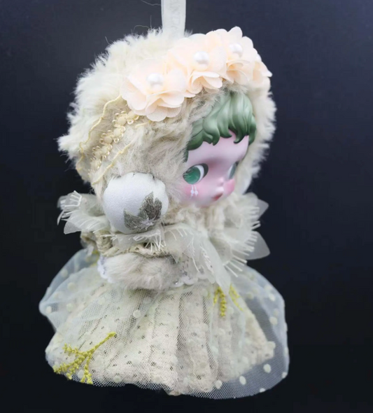 A Skullpanda figure wearing a custom-made, mint-colored feather dress and a fluffy cap with lace trim