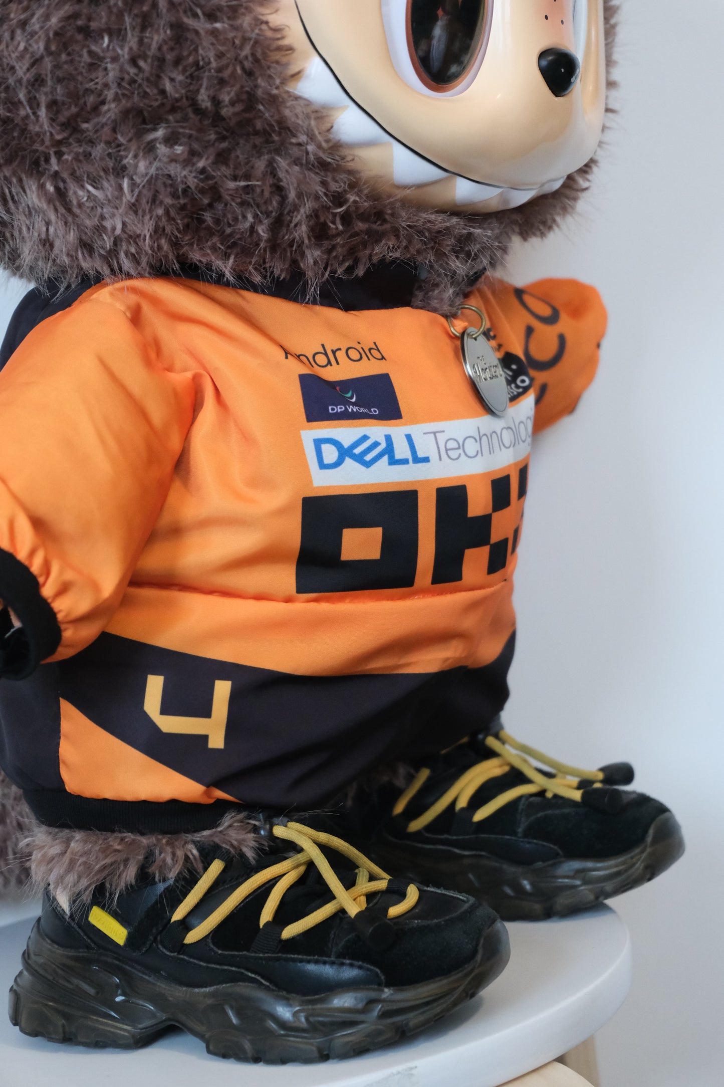 58cm Mega Zimomo wearing a McLaren F1 racing jumpsuit in orange and black