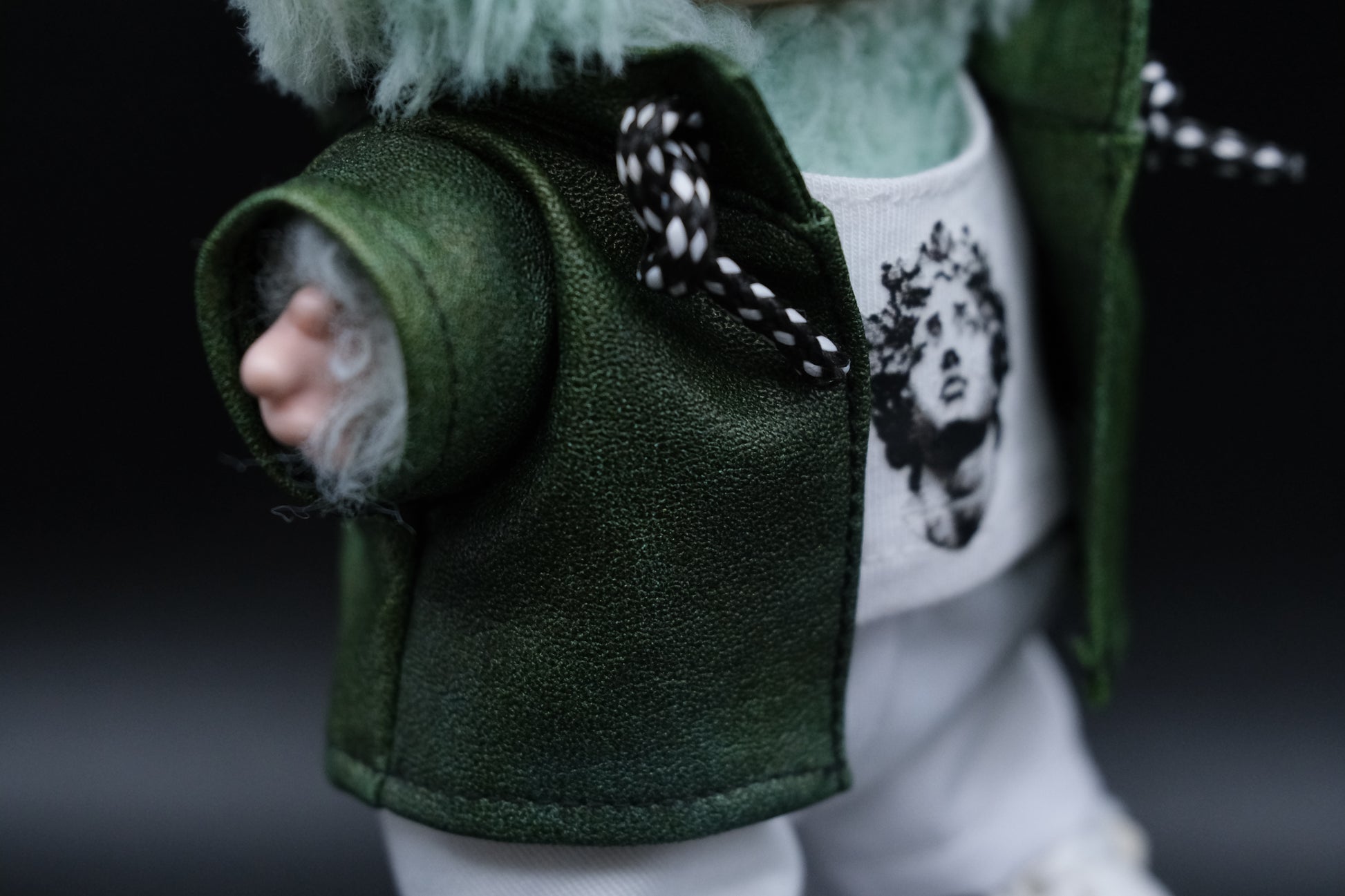 A close up of Labubu  wear a green leather jacket and white t-shirt