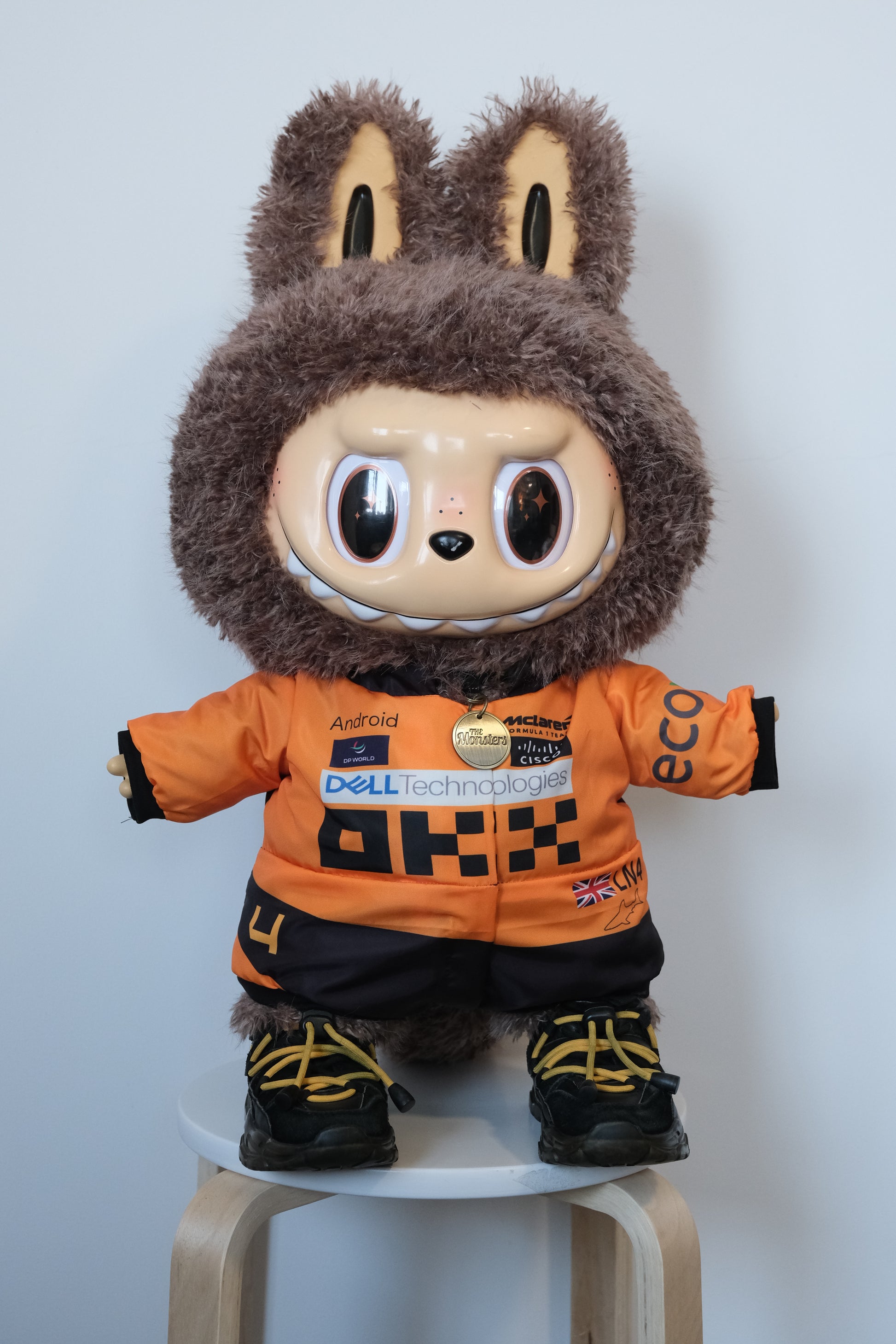 58cm Mega Zimomo wearing a McLaren F1 racing jumpsuit in orange and black